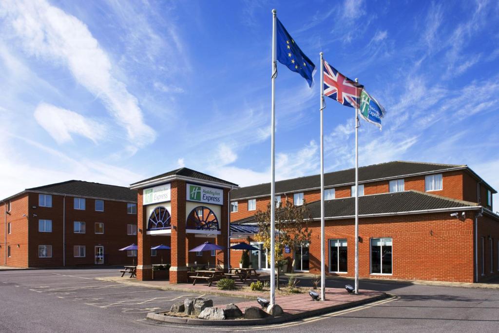 two flags flying in front of a building at Holiday Inn Express Southampton West, an IHG Hotel in Southampton