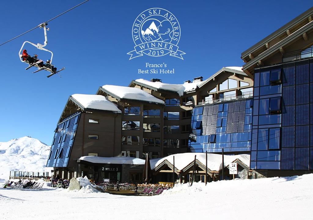 eine Person auf einem Skilift vor einem Hotel in der Unterkunft Altapura Hôtel & Spa Val Thorens in Val Thorens