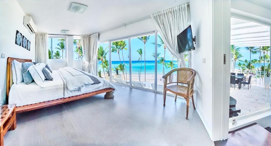 a bedroom with a bed and a view of the ocean at Dream Punta Cana Beachfront Apartment - 4-Bedroom Penthouse with Rooftop BBQ & Ocean Views in Punta Cana