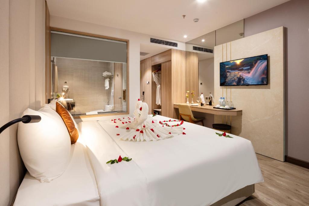 una camera da letto con un grande letto bianco con fiori di Nalicas Nha Trang Hotel a Nha Trang