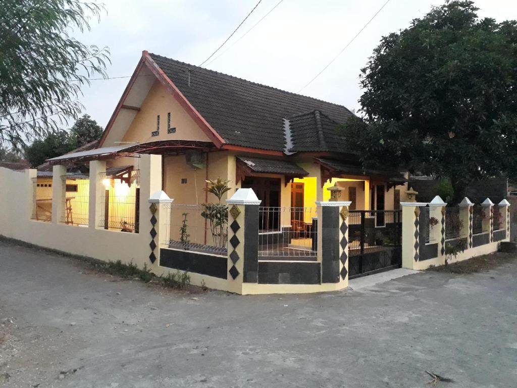 uma casa com uma cerca em frente em Ma Maison Guest House em Yogyakarta