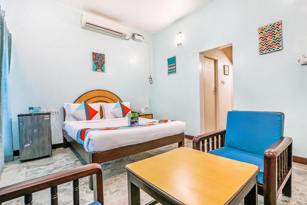 um quarto de hotel com uma cama e uma cadeira em FabExpress Santhi Inn - Near Promenade Beach em Pondicherry