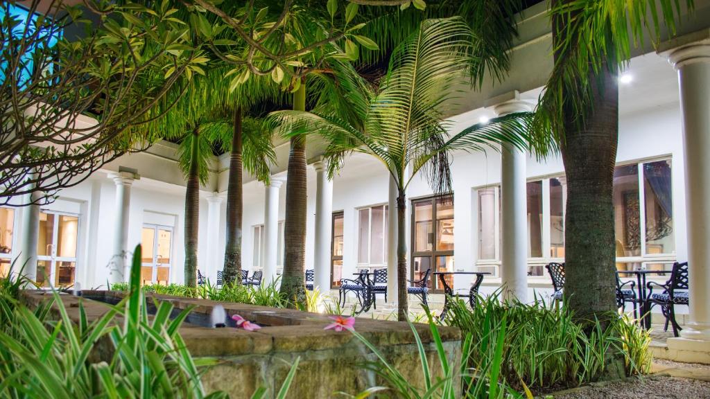 a building with palm trees and tables and chairs at Premier Hotel The Richards in Richards Bay