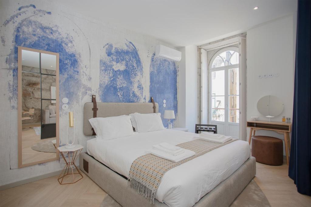 a bedroom with a large bed with a blue wall at Liiiving in Porto - Luxury Beachfront Apartments in Porto