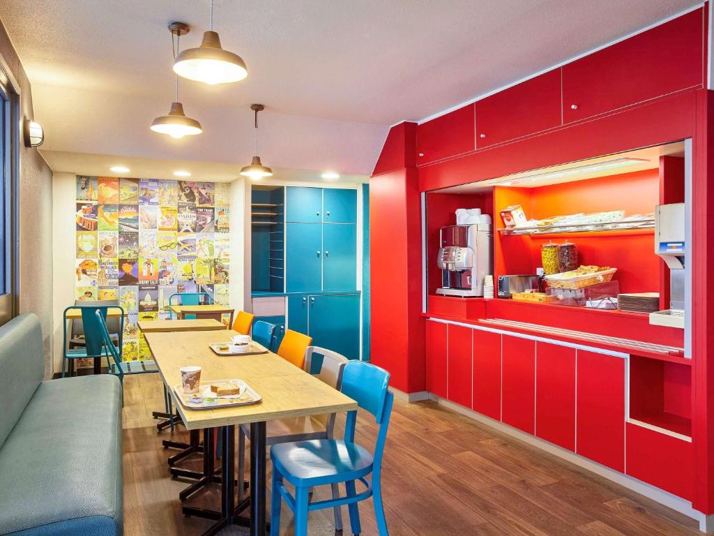 a dining room with red cabinets and a table and chairs at hotelF1 Toulouse L'Union in LʼUnion