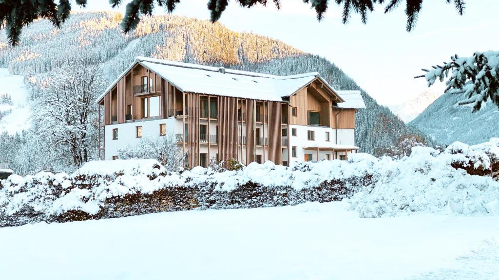 ein schneebedecktes Gebäude vor einem Berg in der Unterkunft Thalers Mariandl in Schladming