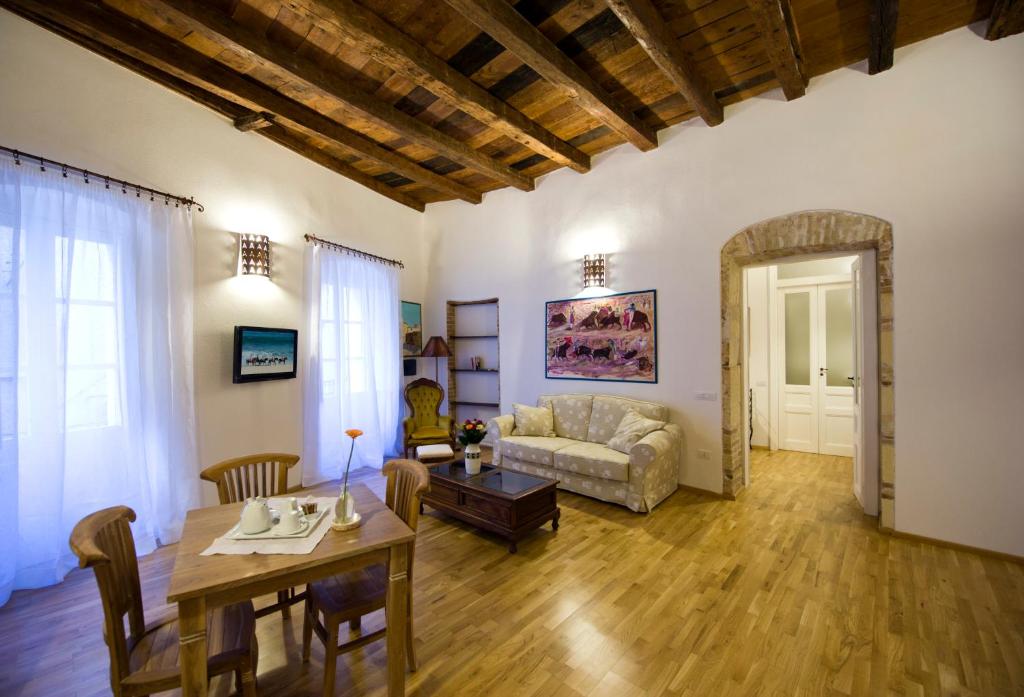 uma sala de estar com uma mesa e um sofá em Castelletto Suites em Cagliari