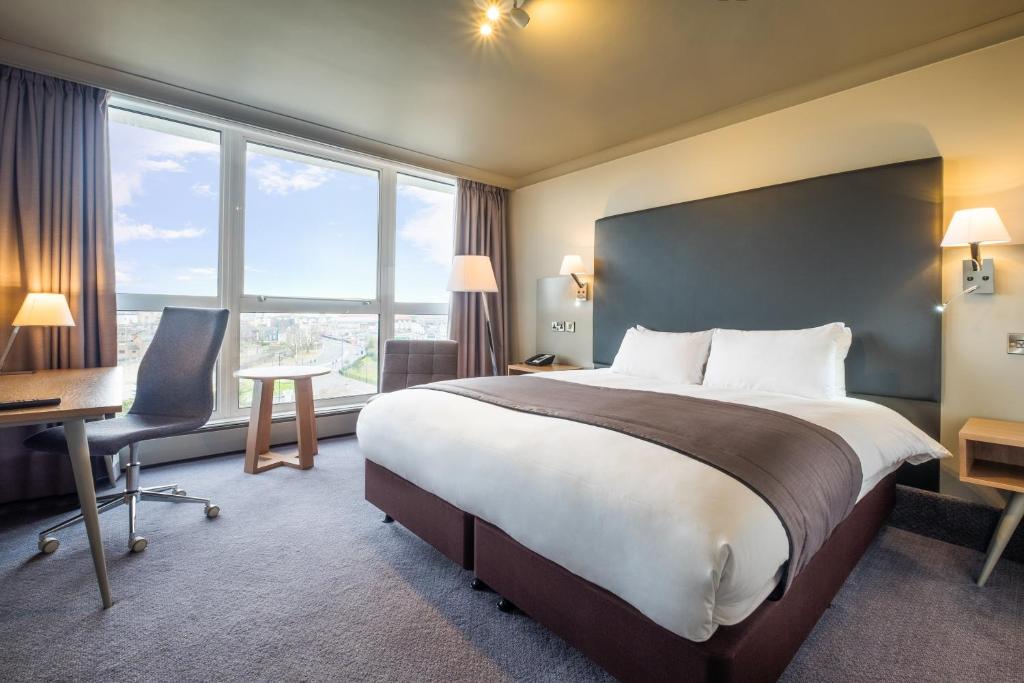 a hotel room with a bed and a desk and window at Holiday Inn Southampton, an IHG Hotel in Southampton