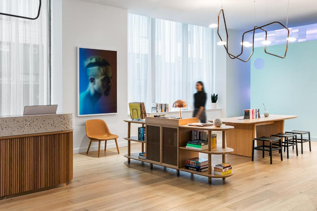 een vrouw in een kamer met een tafel en stoelen bij Mint House at 70 Pine in New York