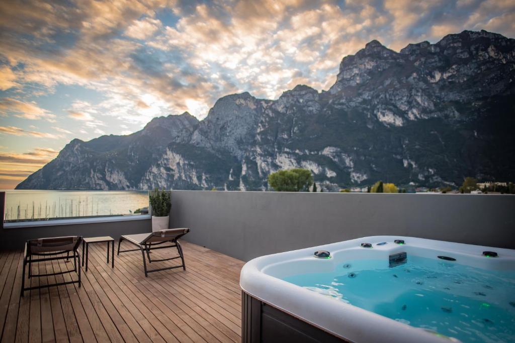 d'un bain à remous sur une terrasse offrant une vue sur la montagne. dans l'établissement Hotel Villa Enrica, à Riva del Garda