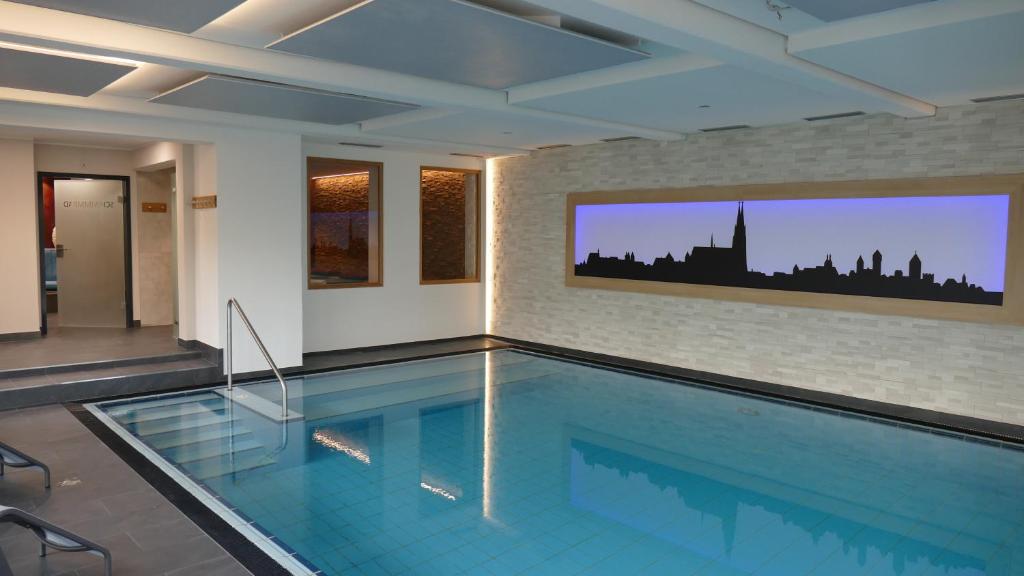 a large swimming pool in a room with a building at Hotel & Gasthof Richard Held in Regensburg