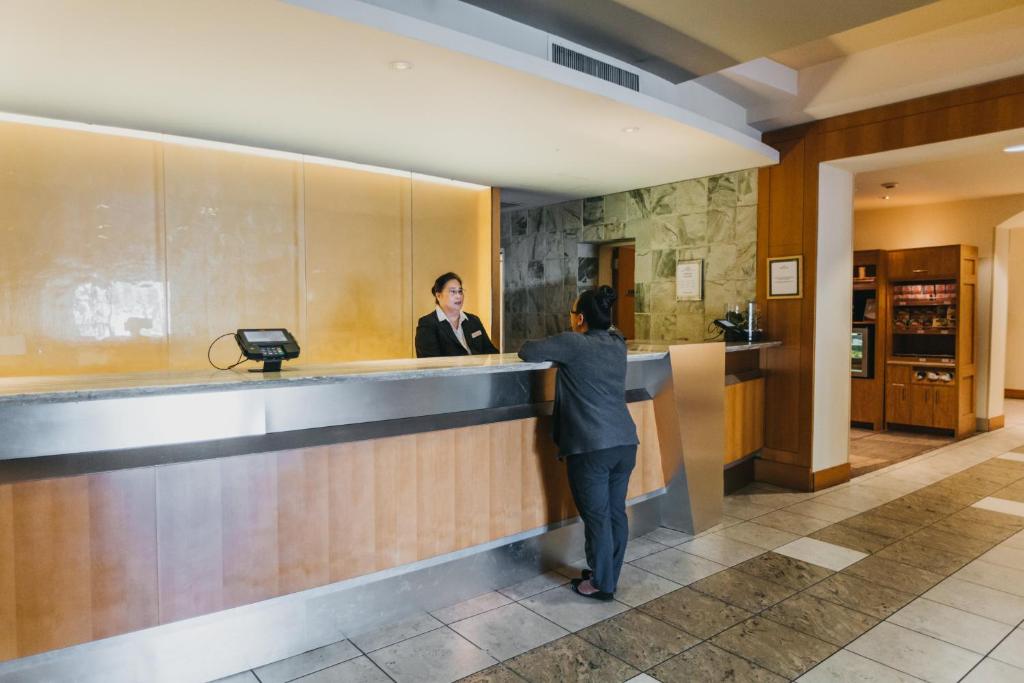 une femme debout au comptoir dans le hall de l'hôtel dans l'établissement Crowne Plaza San Francisco Airport, an IHG Hotel, à Burlingame