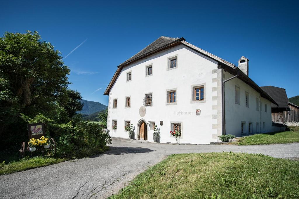 un edificio bianco su una strada accanto a una strada di Hofbauer a Brunico