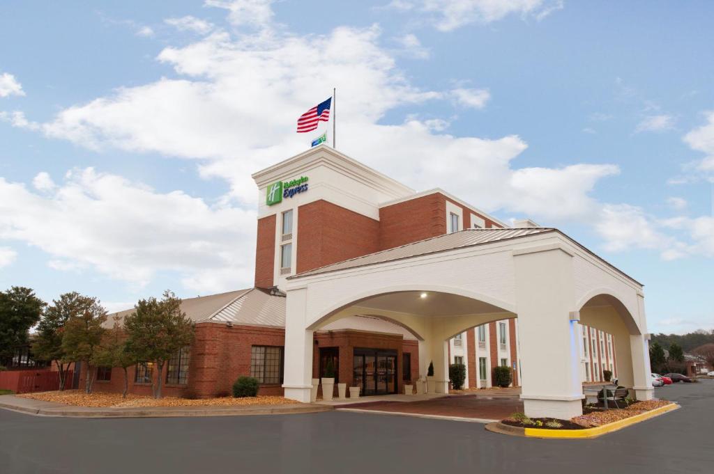 Um edifício com uma bandeira americana em cima. em Holiday Inn Express Fredericksburg - Southpoint, an IHG Hotel em Fredericksburg