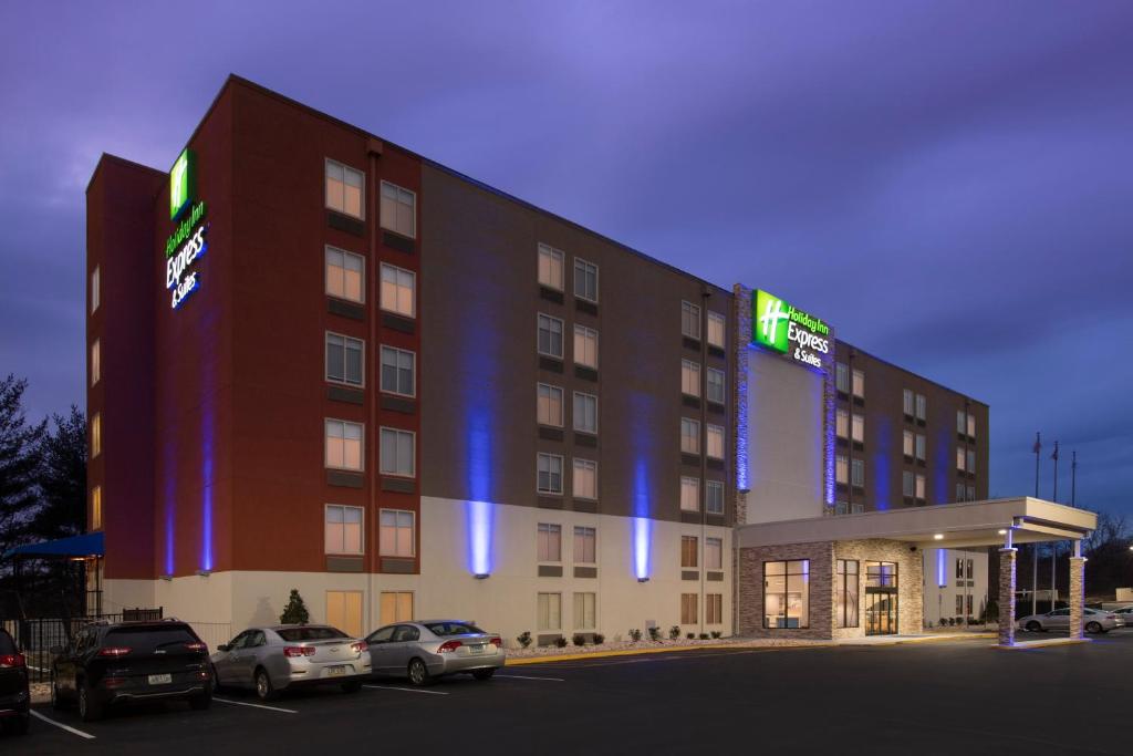 un edificio alberghiero con auto parcheggiate in un parcheggio di Holiday Inn Express & Suites College Park - University Area, an IHG Hotel a College Park