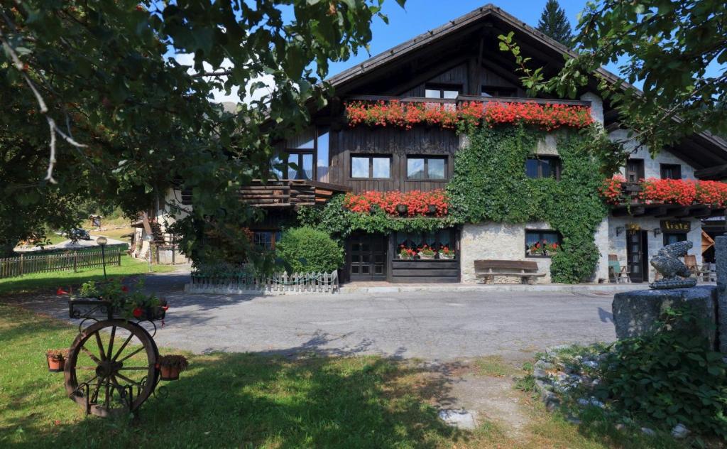 una casa con flores a un lado. en Albergo Ristorante Al Fratè da Streza, en Madonna di Campiglio