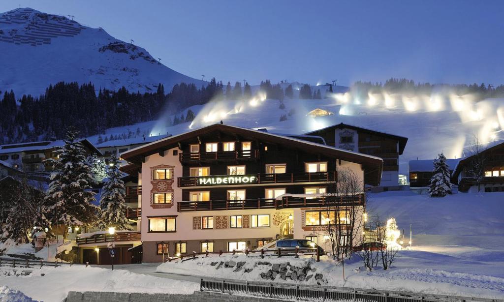 a large ski lodge in the snow at night at Haldenhof in Lech am Arlberg