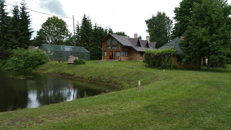 ein Blockhaus mit einem Fluss davor in der Unterkunft Upeslīči atpūtai in Jelgava