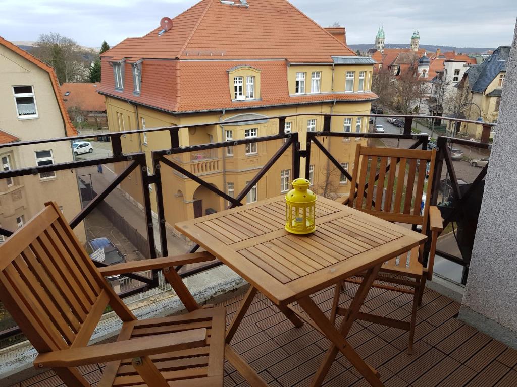 un tavolo in legno e 2 sedie sul balcone di Ferienwohnung mit Domblick a Naumburg