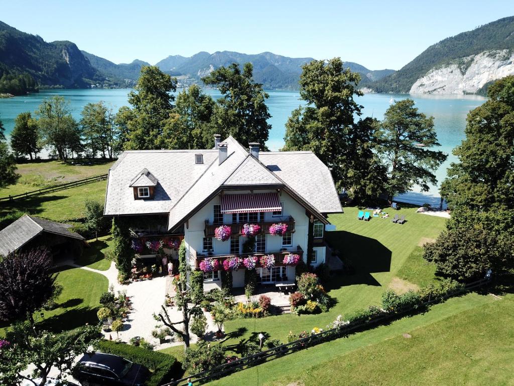 - une vue aérienne sur une maison avec un lac dans l'établissement Landhaus Leitner am Wolfgangsee, à Sankt Gilgen