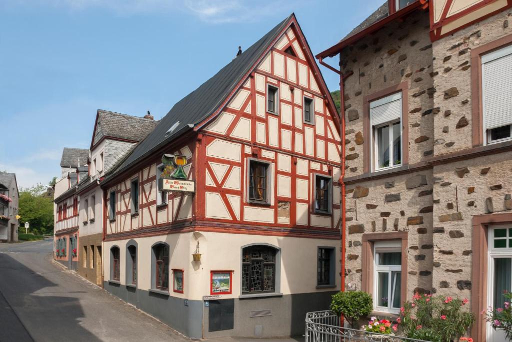 een oud gebouw met rode en witte rand in een straat bij Alte Weinstube Burg Eltz in Treis-Karden