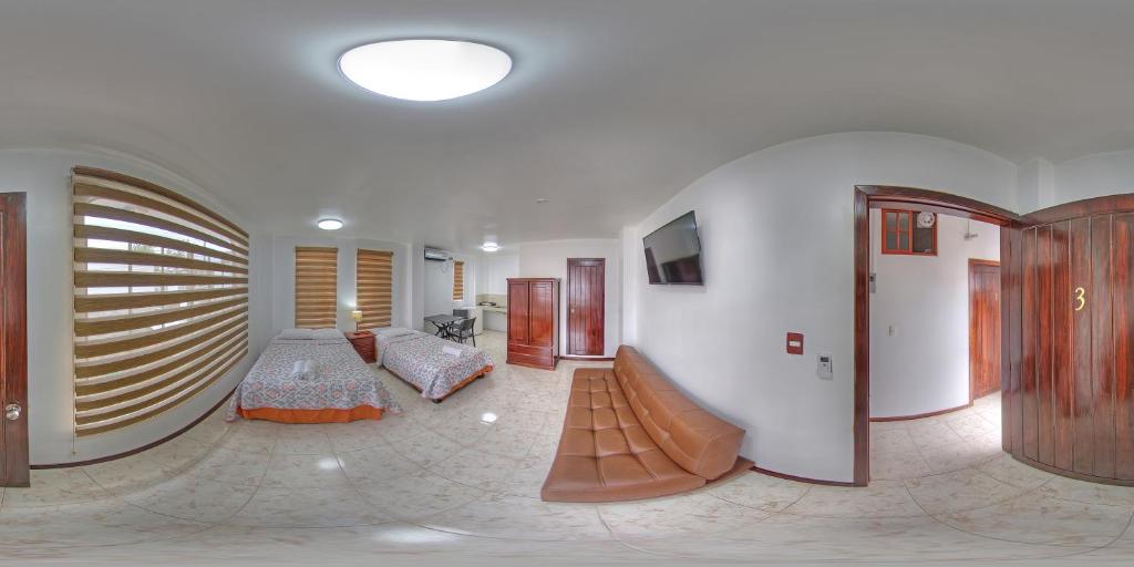 a living room with a bed and a couch at Galapagos Dreams in Puerto Ayora