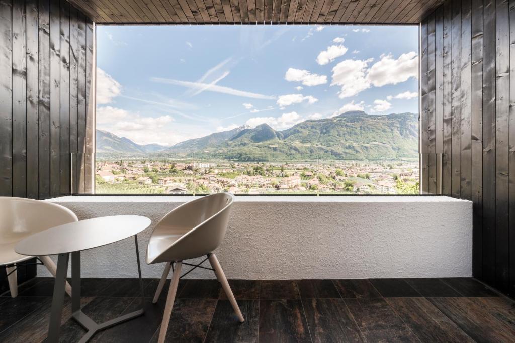 Zimmer mit einem großen Fenster mit Bergblick. in der Unterkunft Garni Hotel Katzenthalerhof in Lana