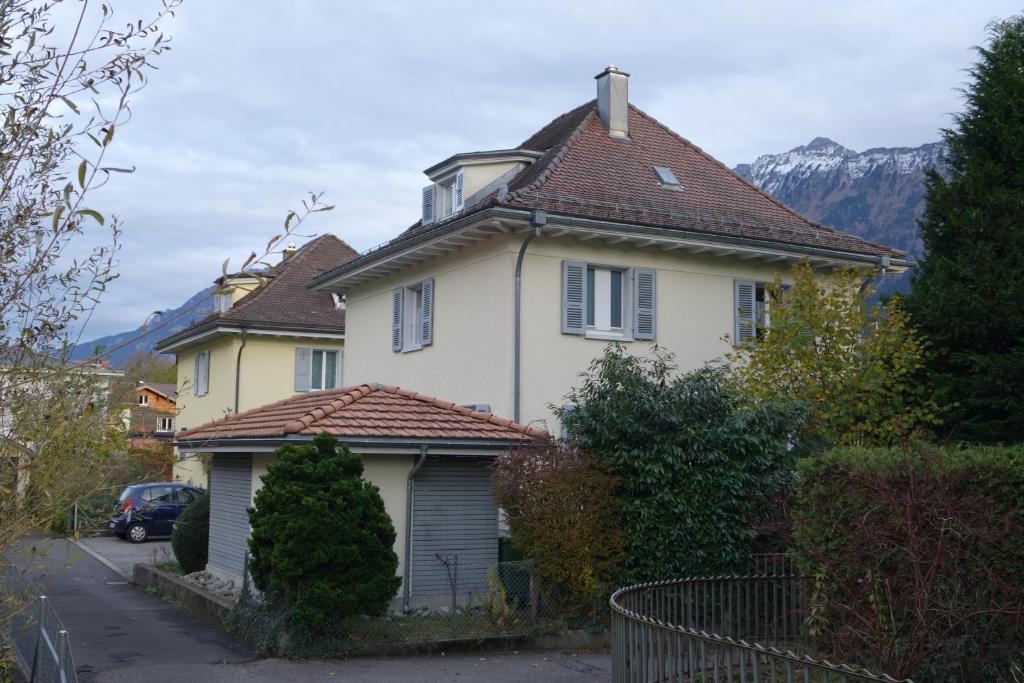 una casa bianca con tetto marrone di ARNOLDS Bed & Breakfast a Interlaken