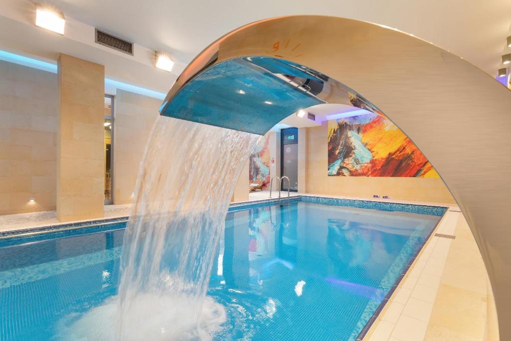 uma grande piscina com uma fonte de água em Hotel La Siesta & Medical Spa em Jastrzębia Góra