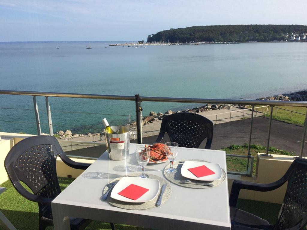 a white table with a plate of food on a balcony at Une terrasse sur la mer in Crozon