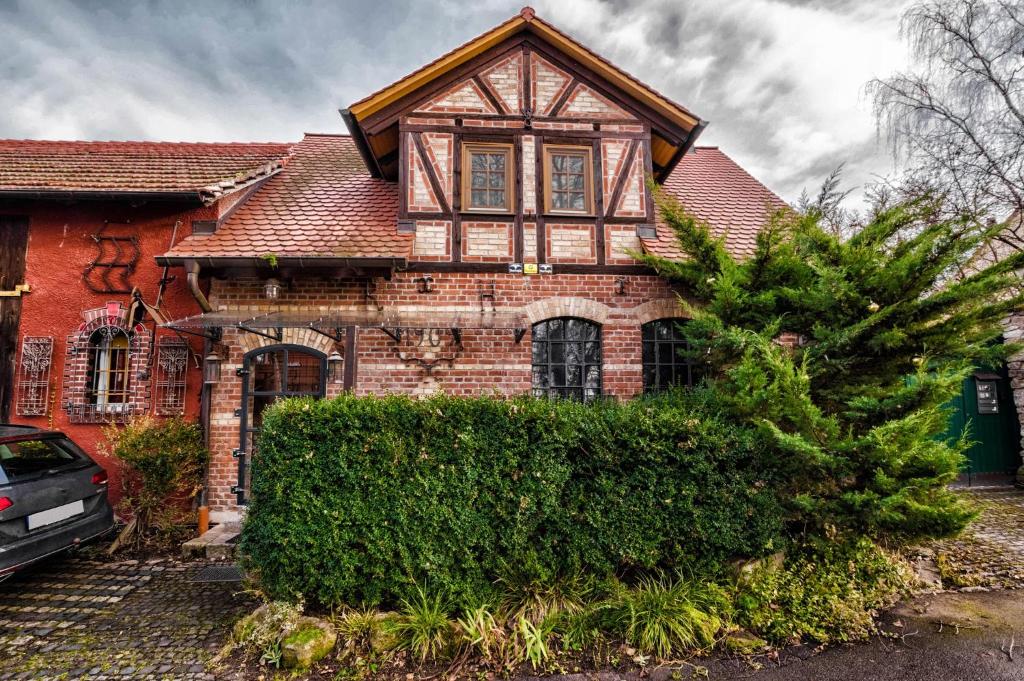 una vieja casa de ladrillo con un árbol delante en Ferienhaus Alte Schmiede, en Erfurt