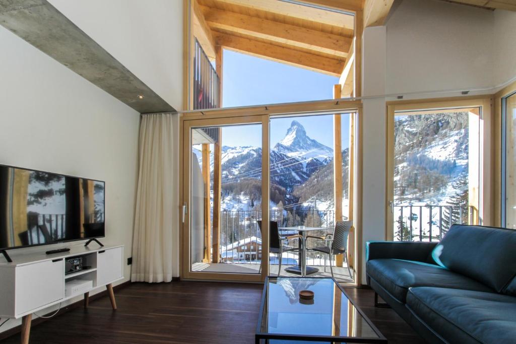 een woonkamer met uitzicht op een berg bij House Mojo in Zermatt