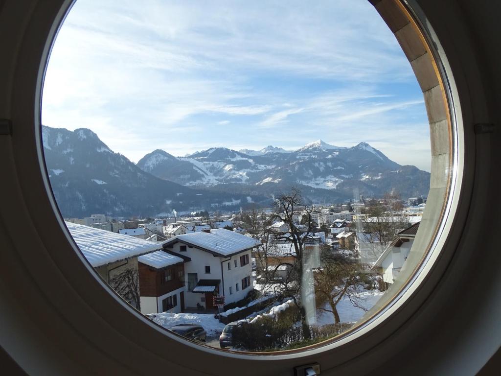 ventana redonda con vistas a la ciudad y a las montañas en Appartement Christiane, en Bludenz