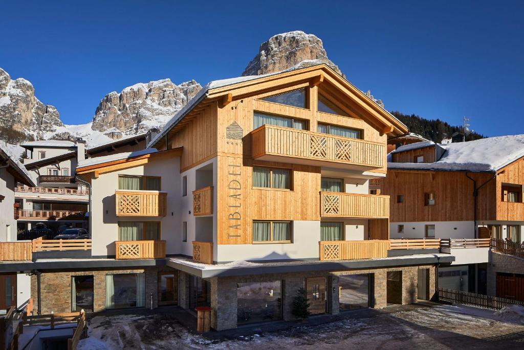 un edificio con una montaña en el fondo en Hotel Tabladel, en Colfosco