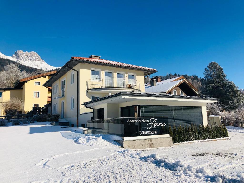 ein Haus mit einem Schild im Schnee in der Unterkunft Appartementhaus Anna in Leogang