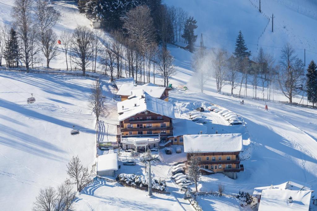 un bâtiment recouvert de neige sur une piste de ski dans l'établissement Der Burgfellnerhof - Adults Only, à Schladming