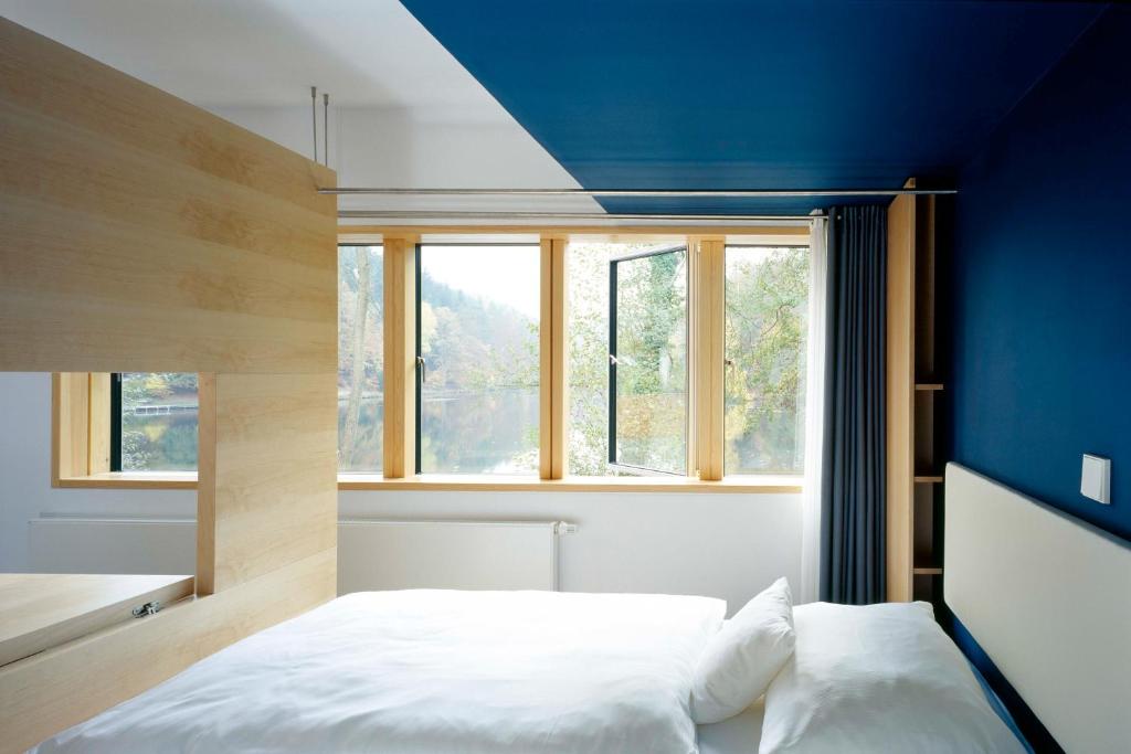 um quarto com uma cama e uma parede azul em seehaus forelle haeckenhaus em Ramsen