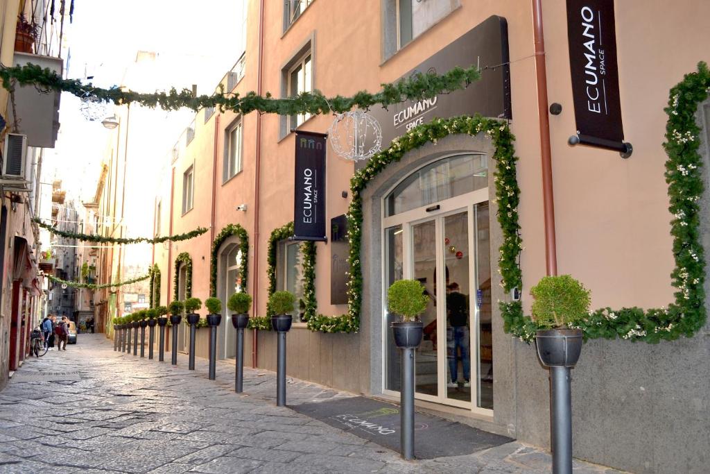 een straat met potplanten voor een winkel bij Ecumano Space in Napels