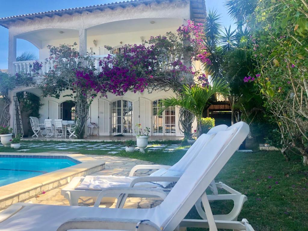 eine Gruppe von Liegestühlen neben einem Pool in der Unterkunft Villa Saint Tropez in Cabo Frio