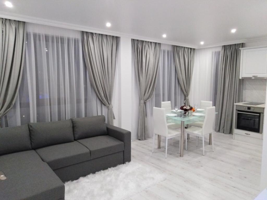 uma sala de estar com um sofá e uma mesa em Vip Luxury APARTMENT em Burgas