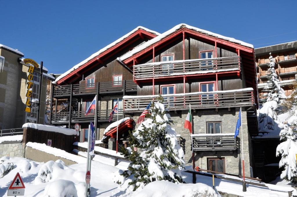 a large building with snow in front of it at Hotel Biancaneve in Sestriere