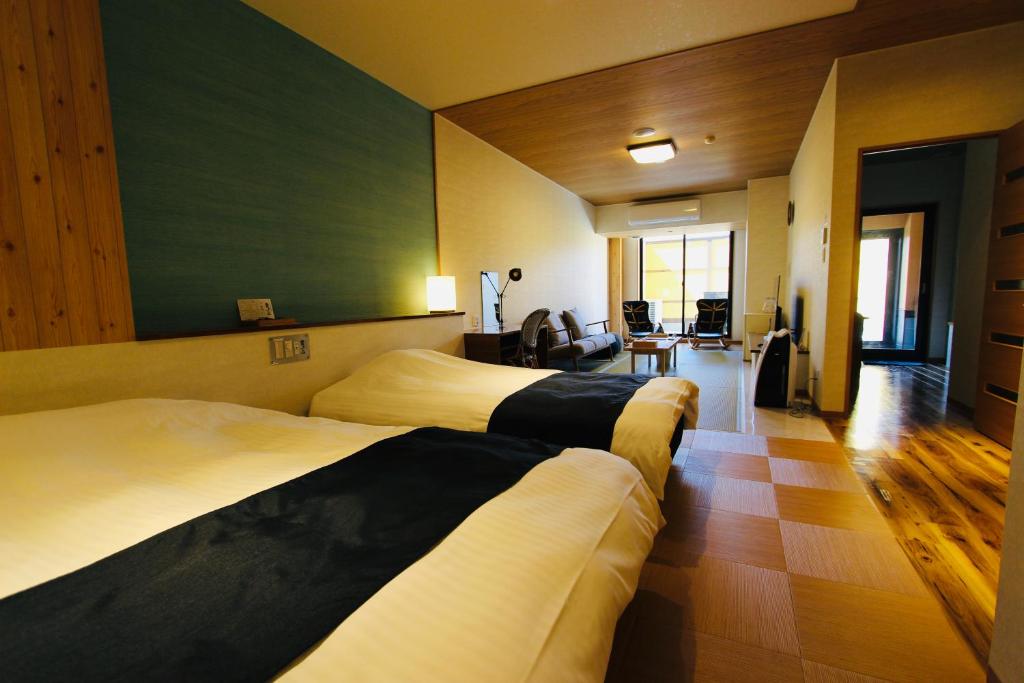 a hotel room with two beds and a living room at Kajitsu no Mori in Ichinoseki