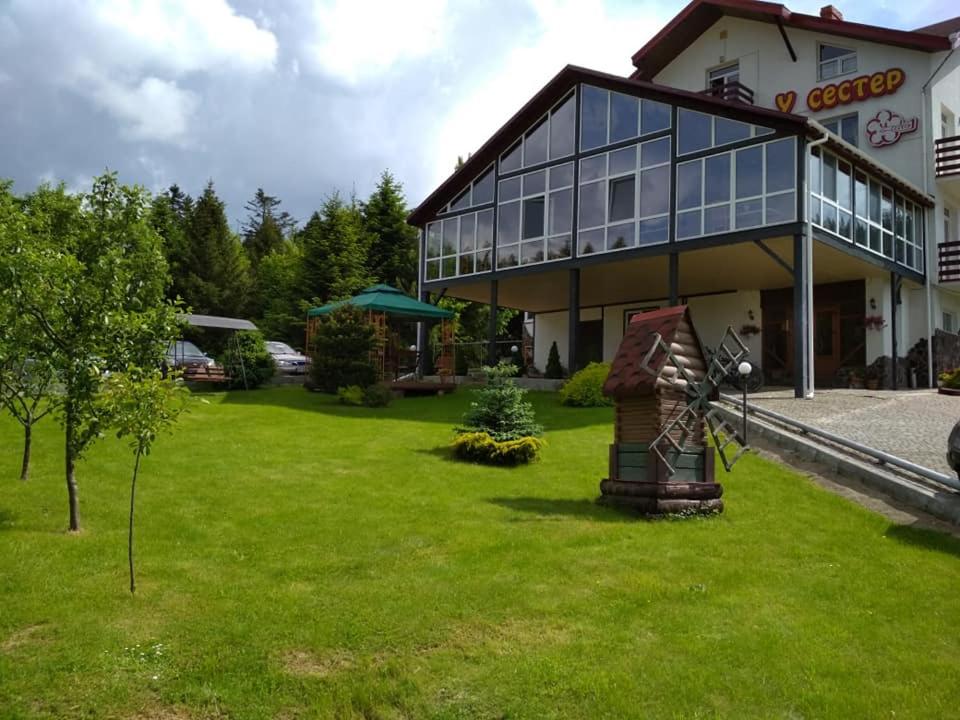 um grande edifício com um relvado em frente em Guest House U Sester em Skhidnitsa