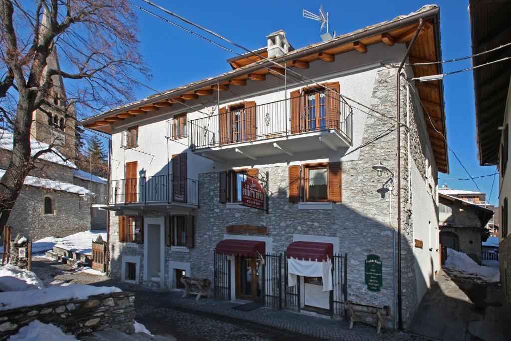 a building with a balcony on the side of it at Eydappartamenti in Sauze dʼOulx