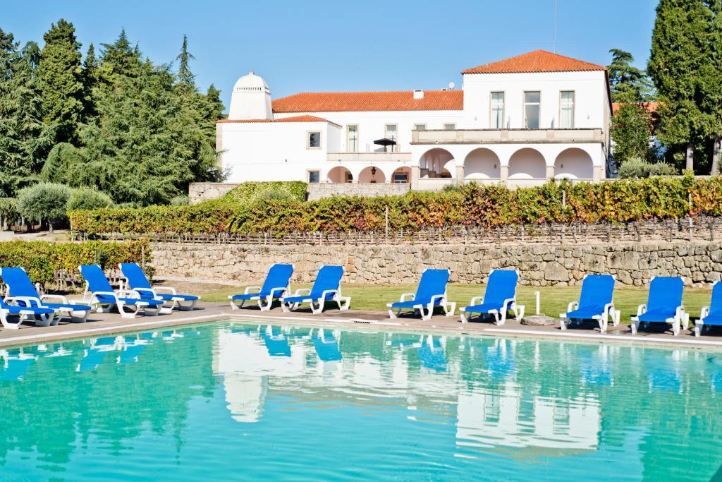 una fila de tumbonas azules junto a una piscina en Flag Hotel Convento do Desagravo, en Oliveira do Hospital