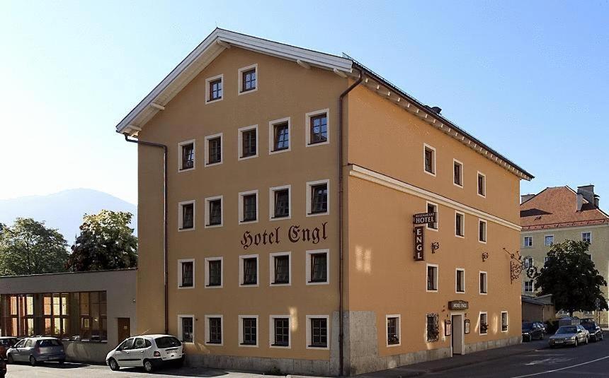 un grand bâtiment avec une voiture garée devant lui dans l'établissement Hotel Engl, à Innsbruck