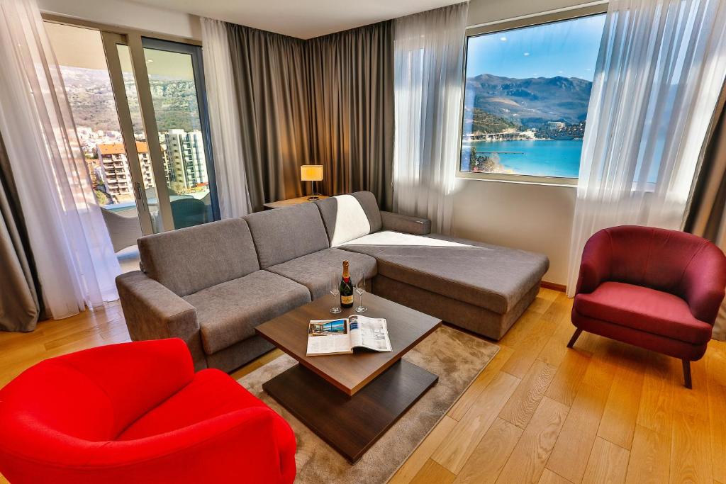 uma sala de estar com um sofá e uma cadeira vermelha em Victoria Apartments em Budva