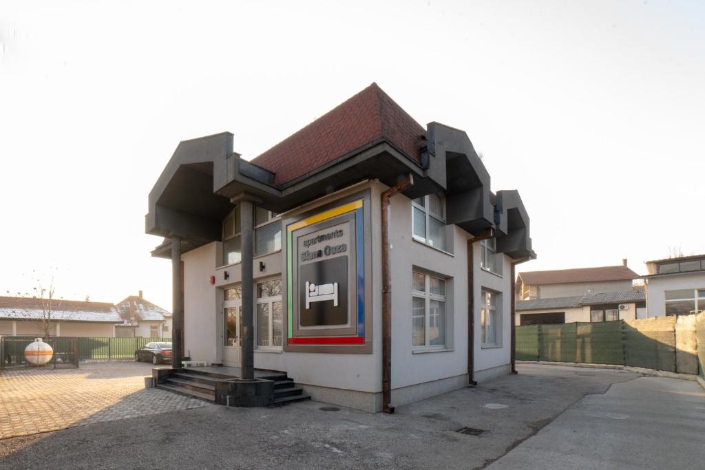 a small white building with a brown roof at Apartments Slana Oaza in Tuzla