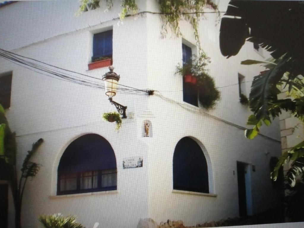 a white building with a street light on it at La Casita - centro histórico y playa in Sitges