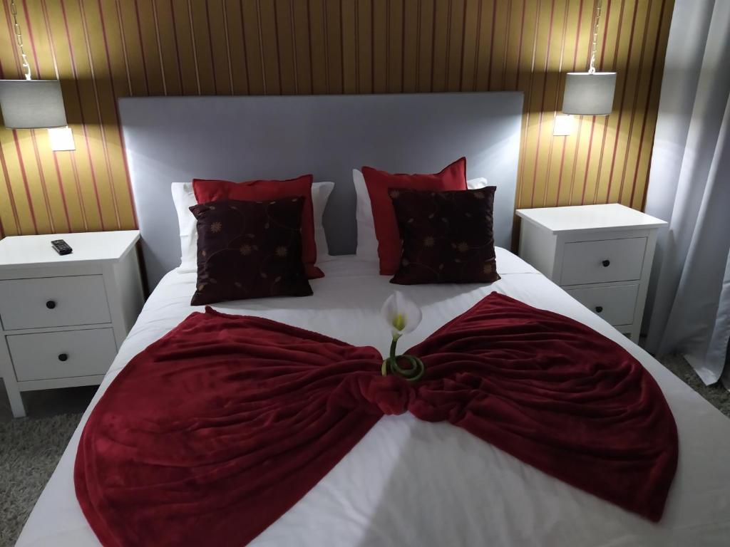 a bedroom with a large bed with a red and white blanket at Casa da Leninha in Nazaré